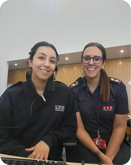 Two colleagues sit together at a reception desk.