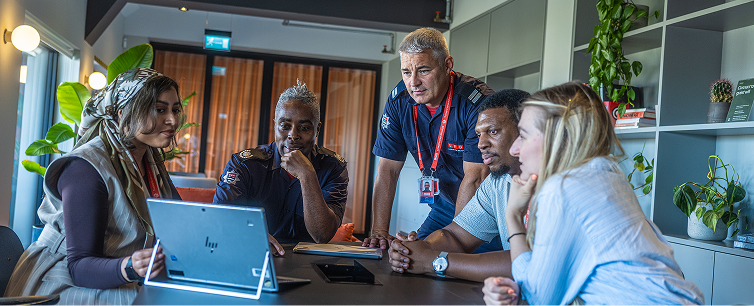 Group of people watching laptop screen